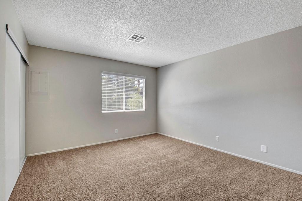 an empty room with carpet and a window