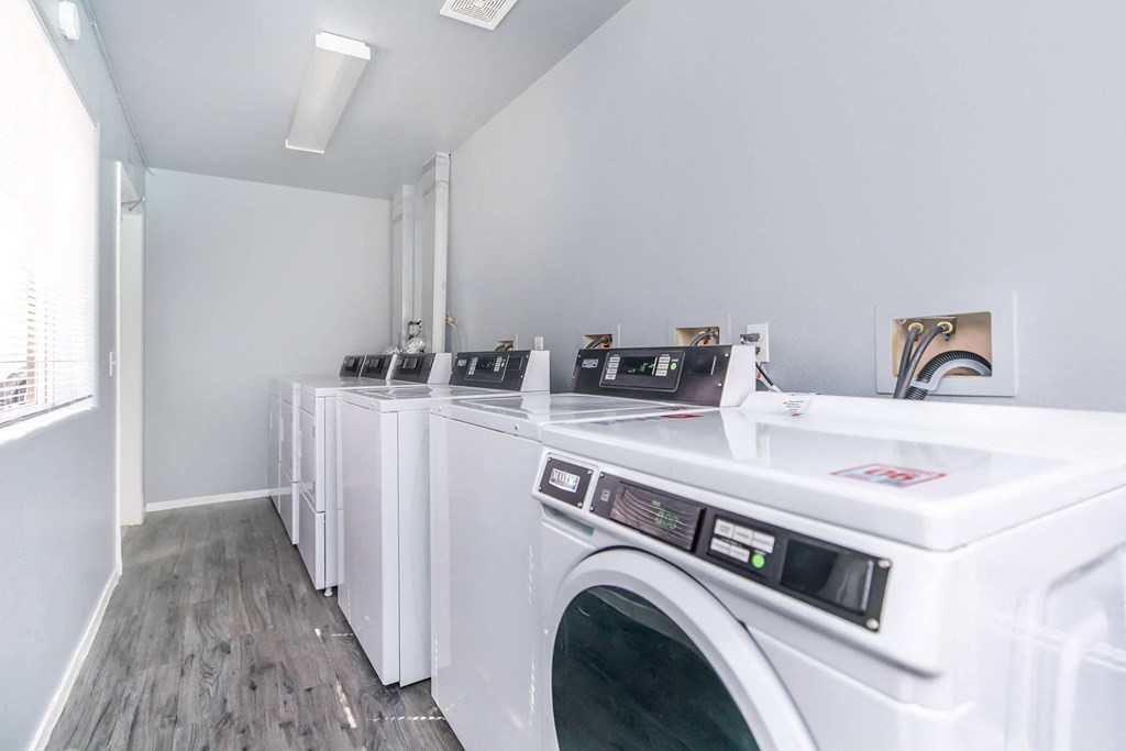 a row of washers and dryers in a laundry room
