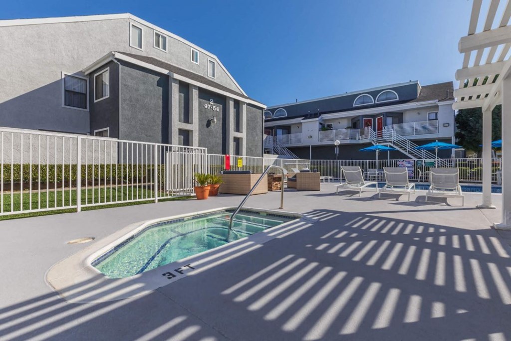 a pool with chairs around it next to a building