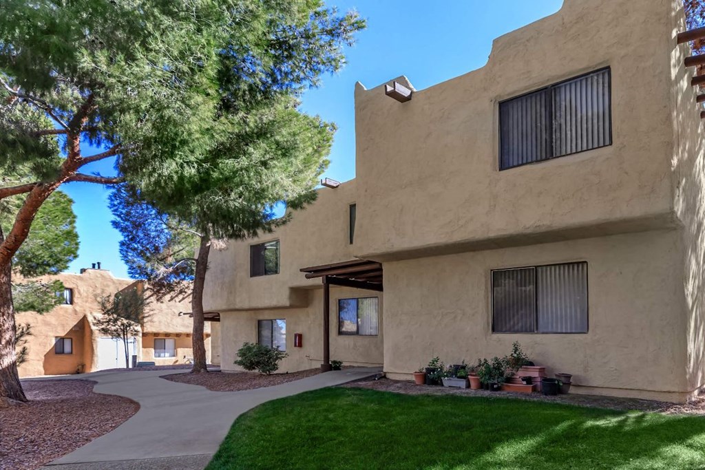 A beige building with a green lawn in front.