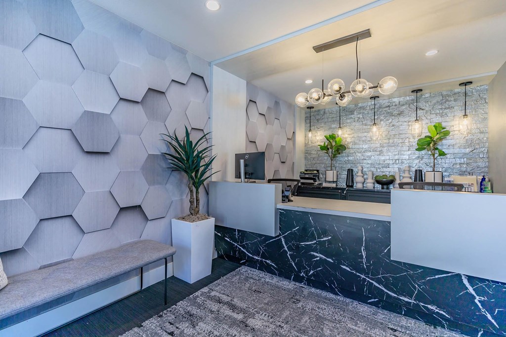 a lobby with a reception desk and a wall with hexagons