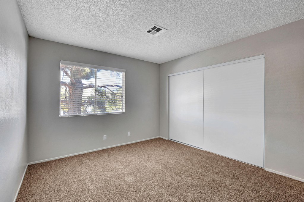 an empty room with carpet and a window