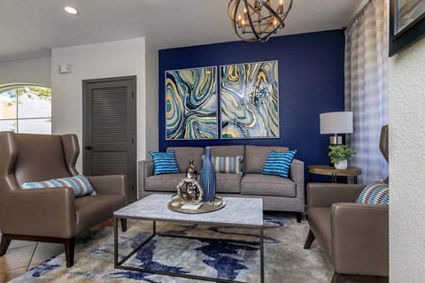 a living room with a blue accent wall and couches