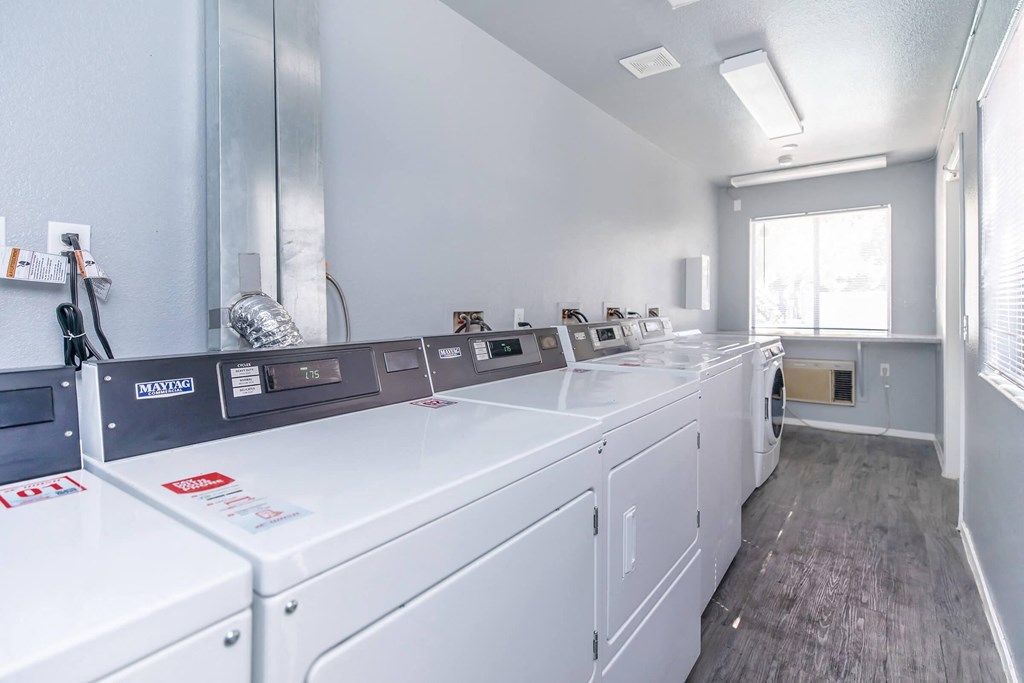 a laundry room with washers and dryers and a window