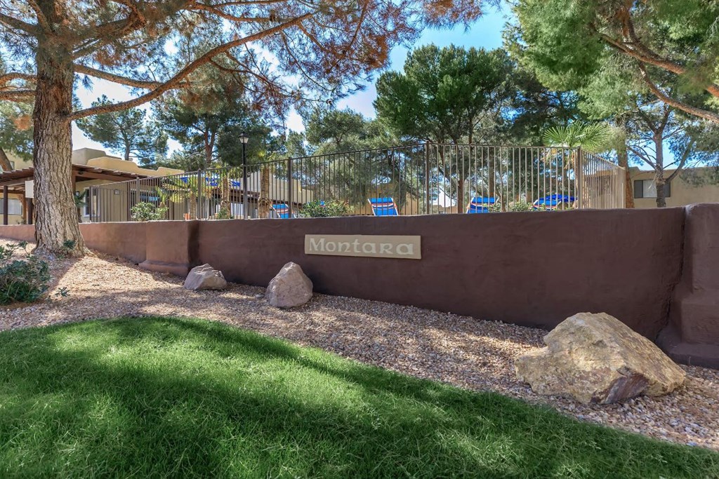 A sign that says "Montara" is on a wall in front of a grassy area.