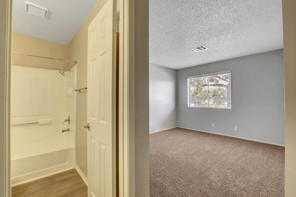 an empty bedroom with a door to a closet and a window