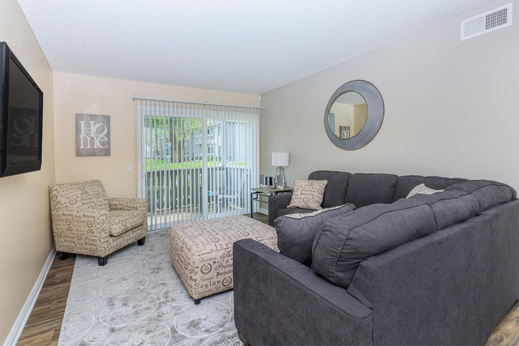 a living room with a couch and a chair and a television