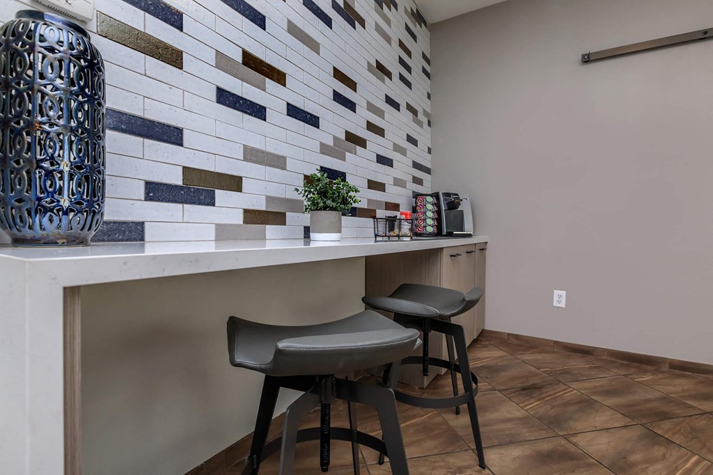 two stools at a counter in a kitchen with a tile wall
