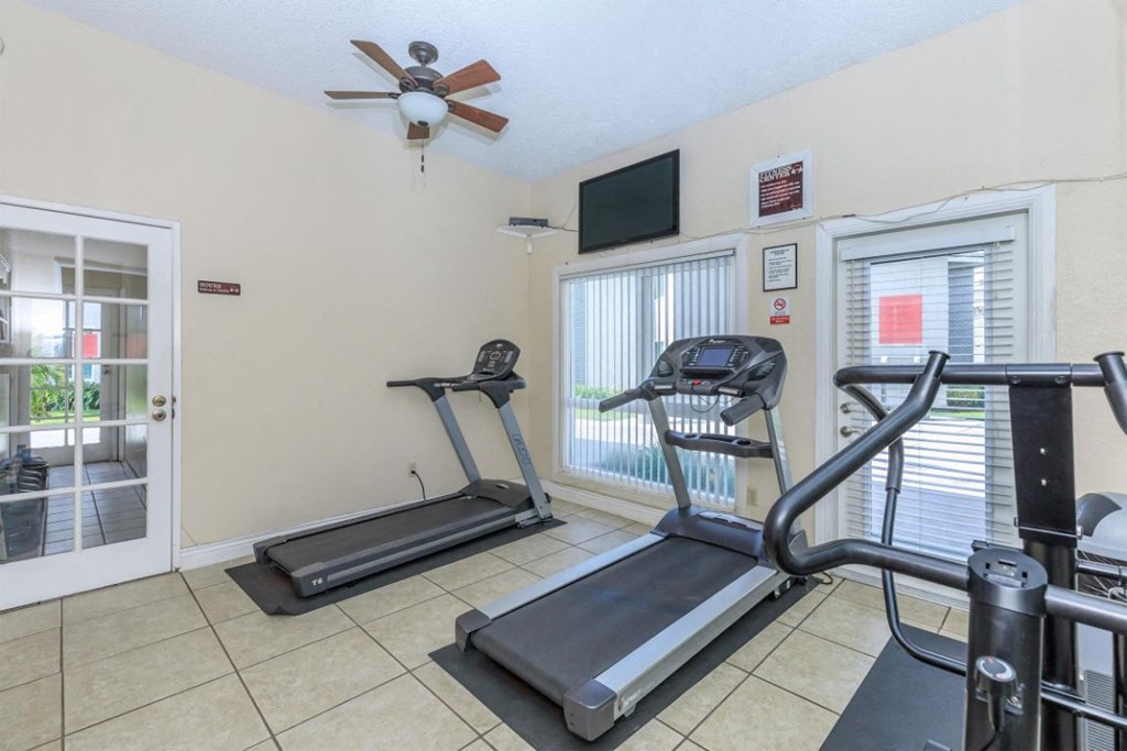 the gym has two treadmills and a ceiling fan