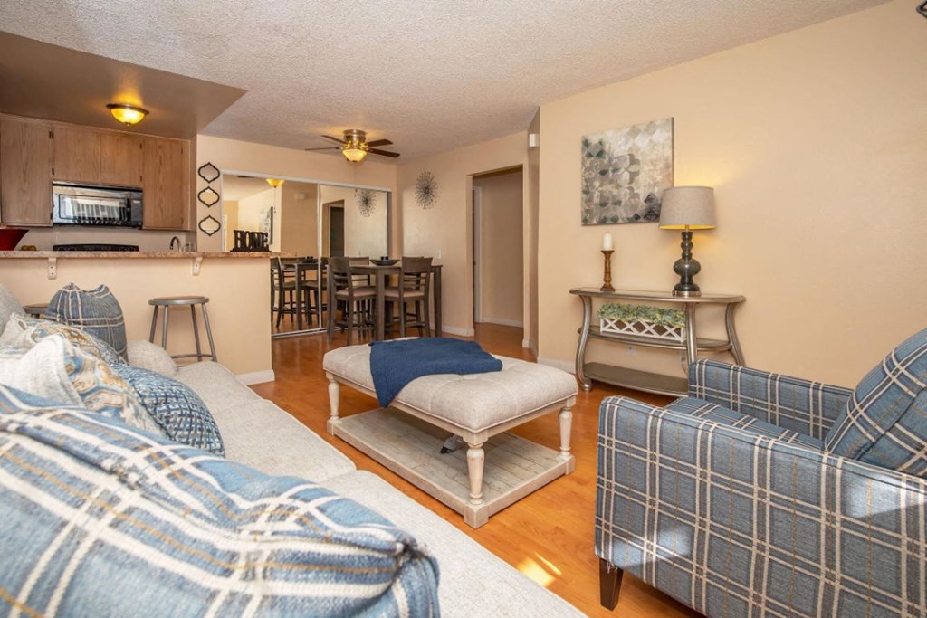 a living room with couches and a kitchen with a dining room table