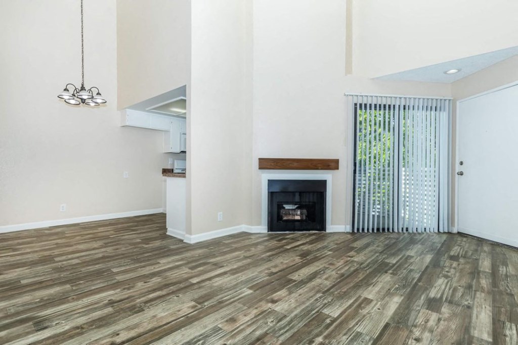 the living room with wood flooring and a fireplace