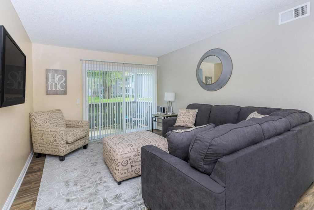 a living room with a couch and a chair and a tv