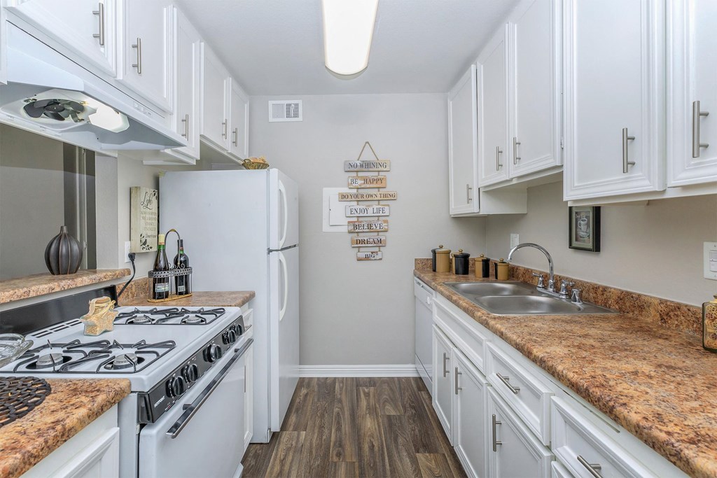 a kitchen with white cabinets and white appliances and counter tops