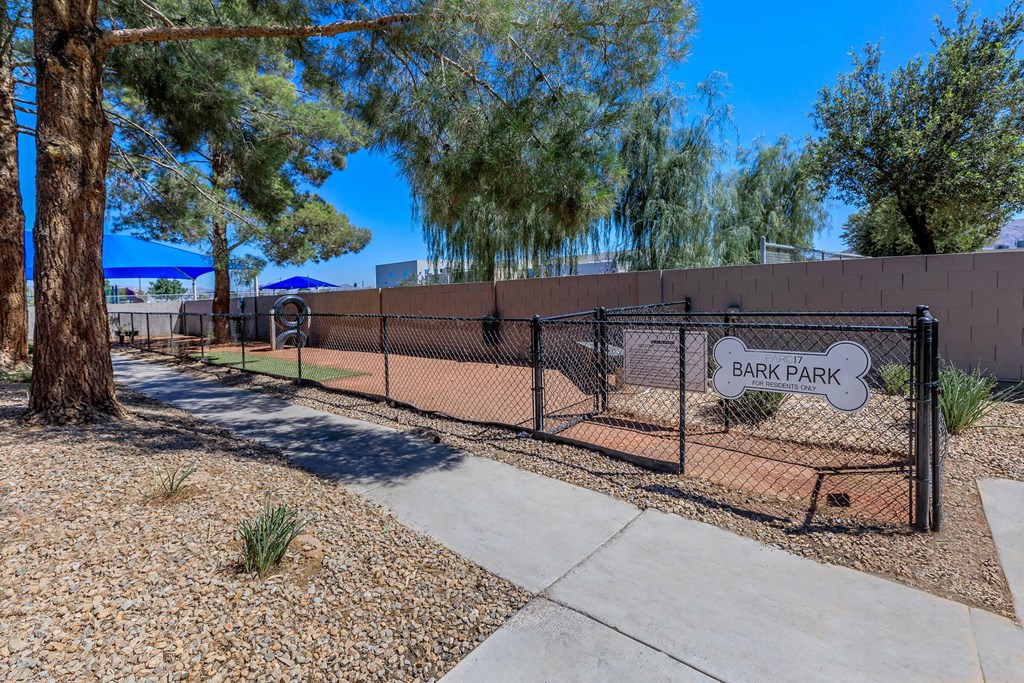 a fence with a sign for bark park in front of a dog park