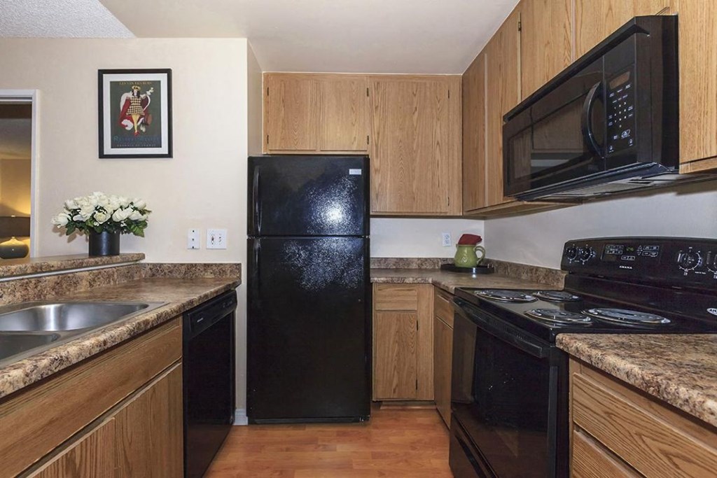 a kitchen with black appliances and wooden cabinets