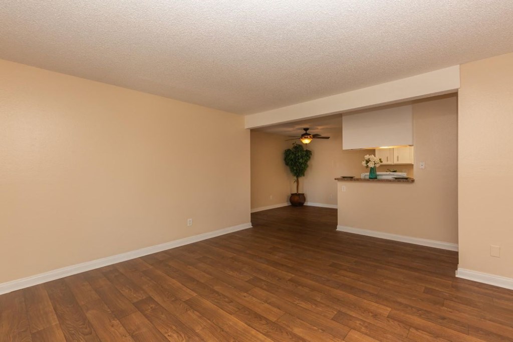 an empty living room with a hard wood floor