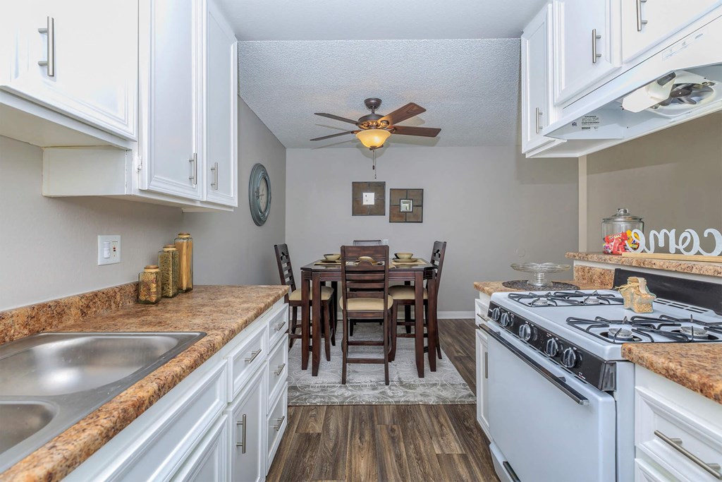 a kitchen and dining room with a stove and a ceiling fan