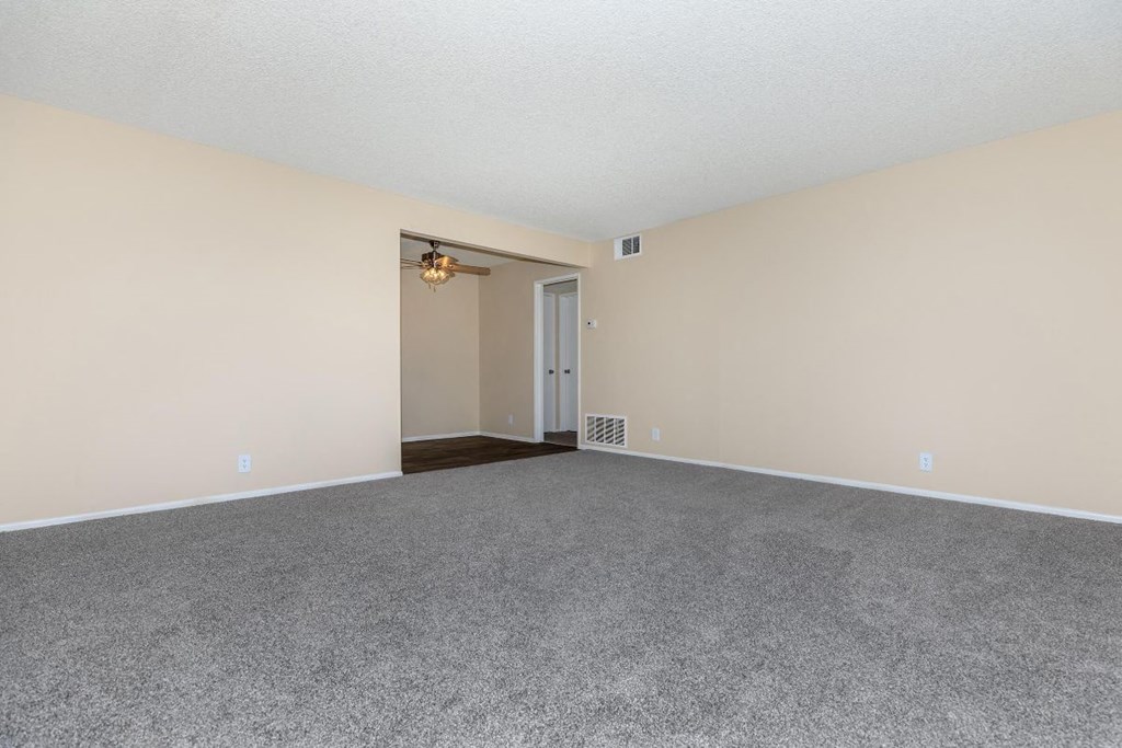 A room with a grey carpet and a white ceiling.