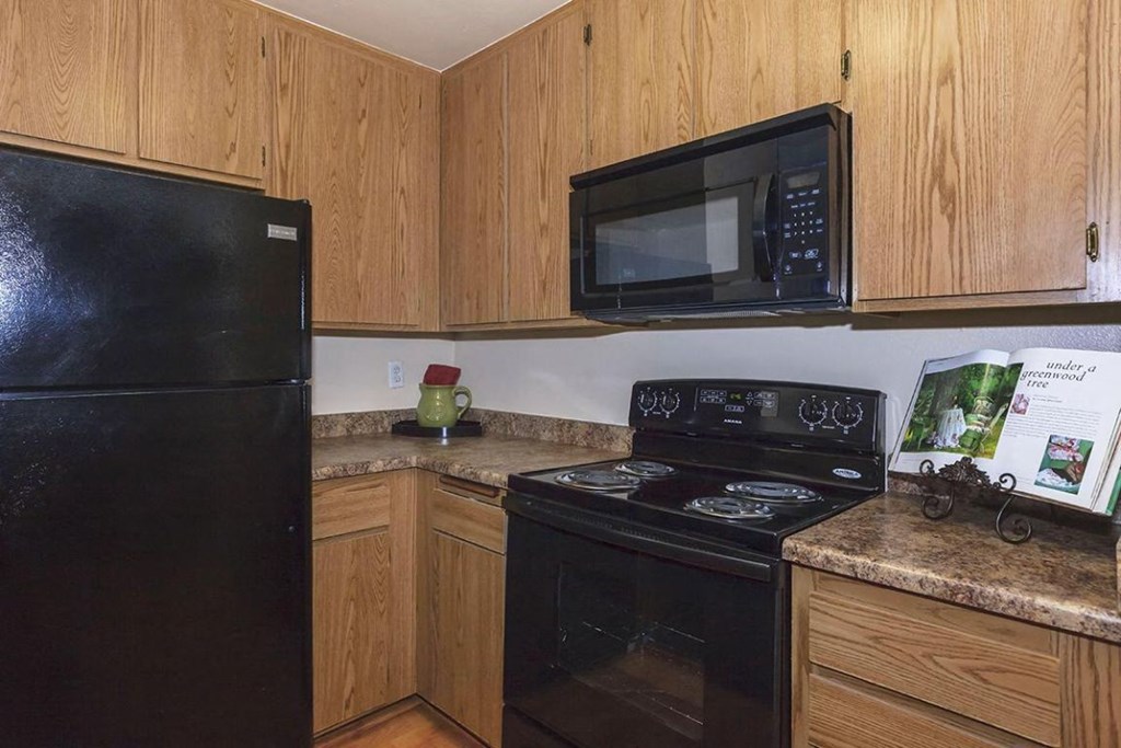 a kitchen with black appliances and wooden cabinets