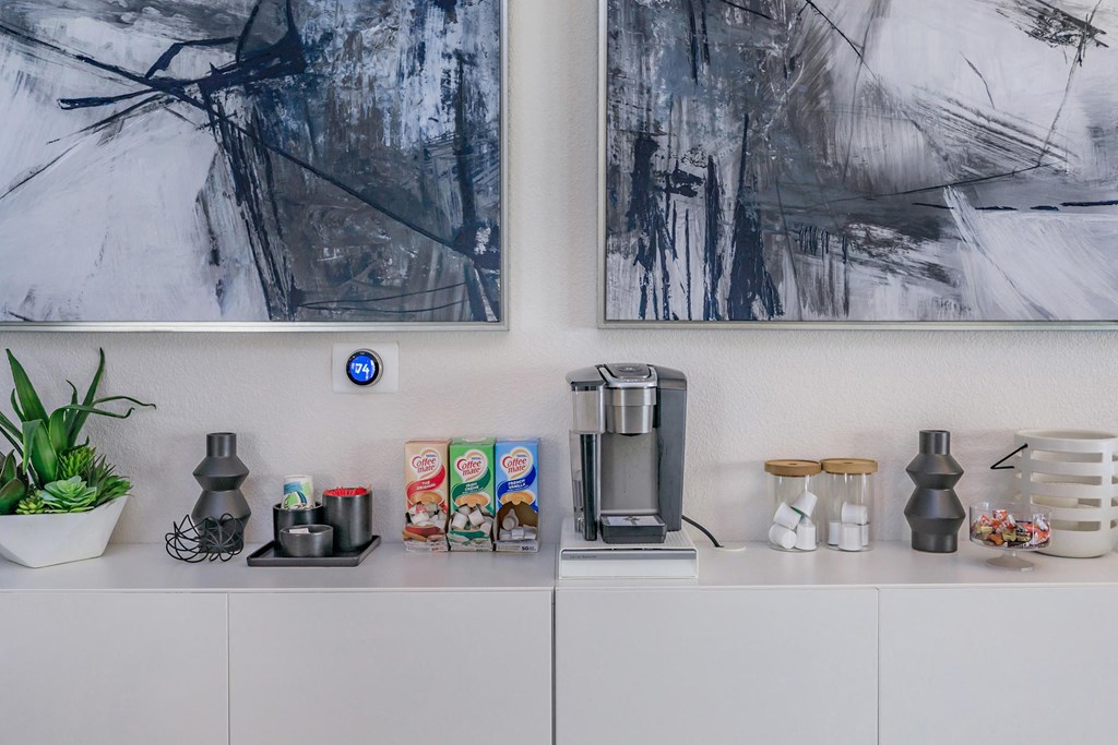 a white counter with a coffee maker and a coffee pot on it