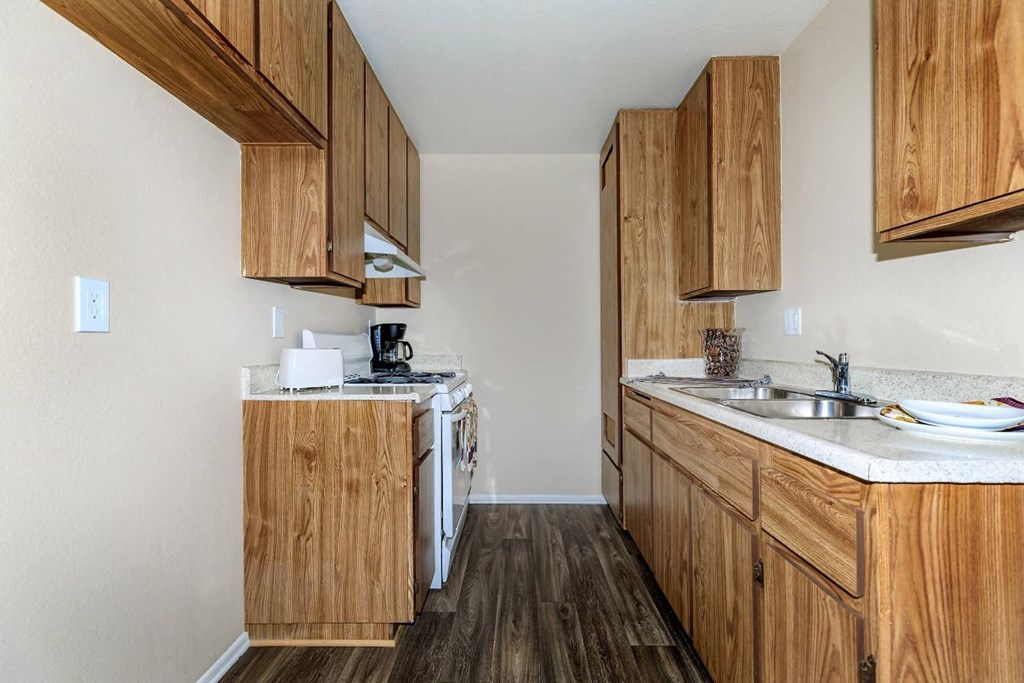 A kitchen with wooden cabinets and a white dishwasher.