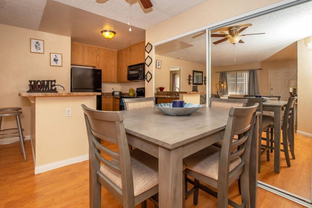 a dining room table with chairs next to a kitchen