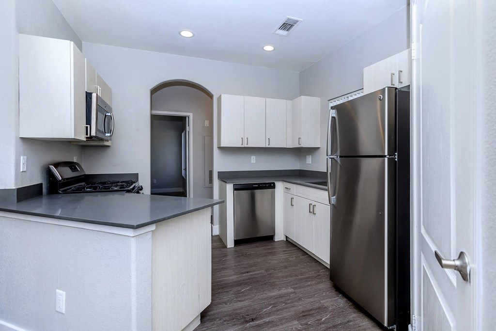 a kitchen with white cabinets and a stainless steel refrigerator