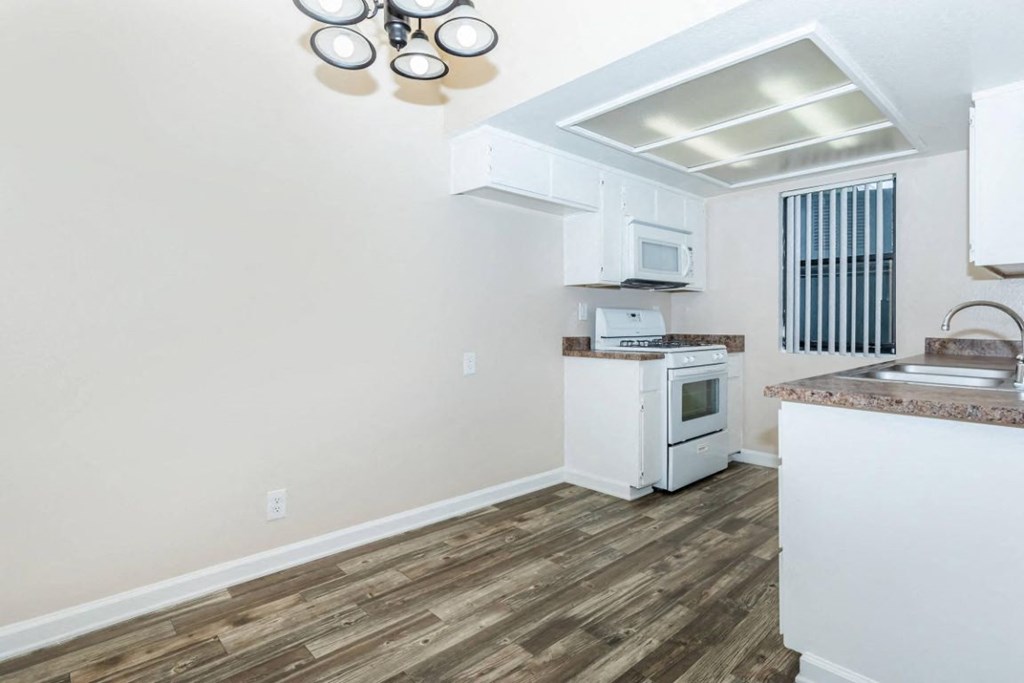a kitchen with a stove and a sink and a microwave