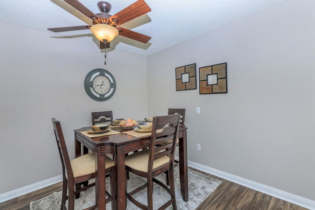 a dining room with a table and chairs under a ceiling fan