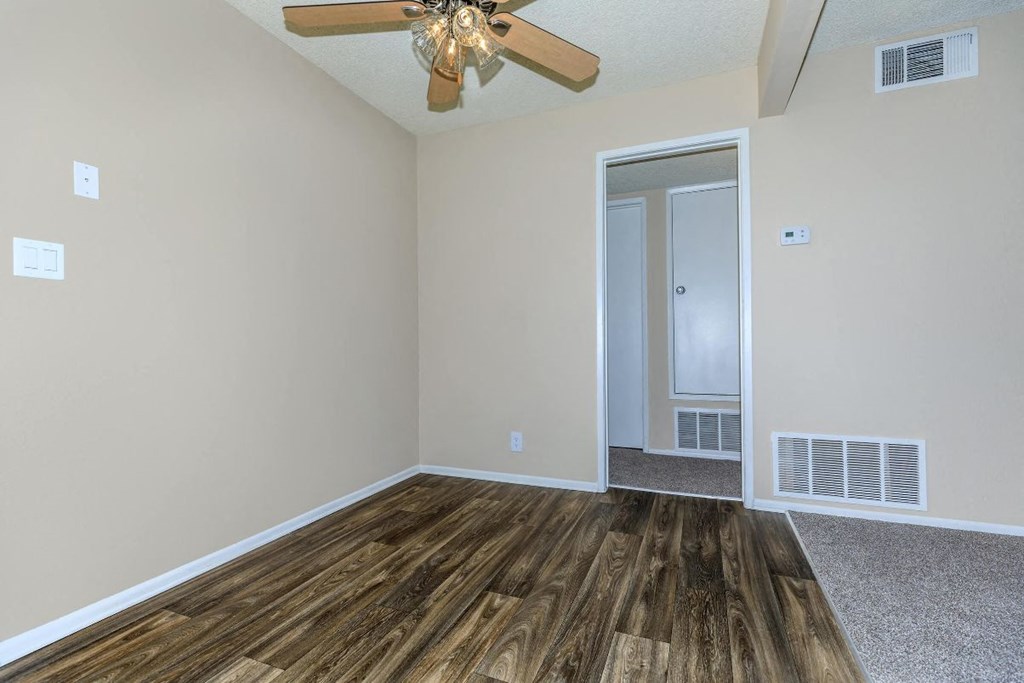 A room with a wooden floor and a ceiling fan.