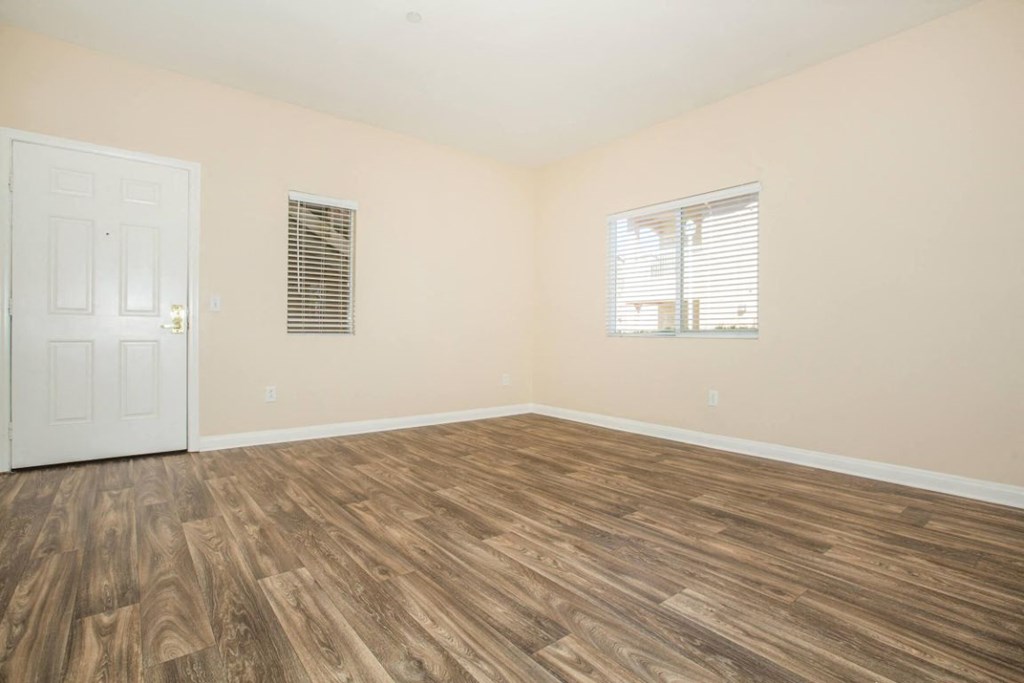 A room with wooden flooring and a white door.