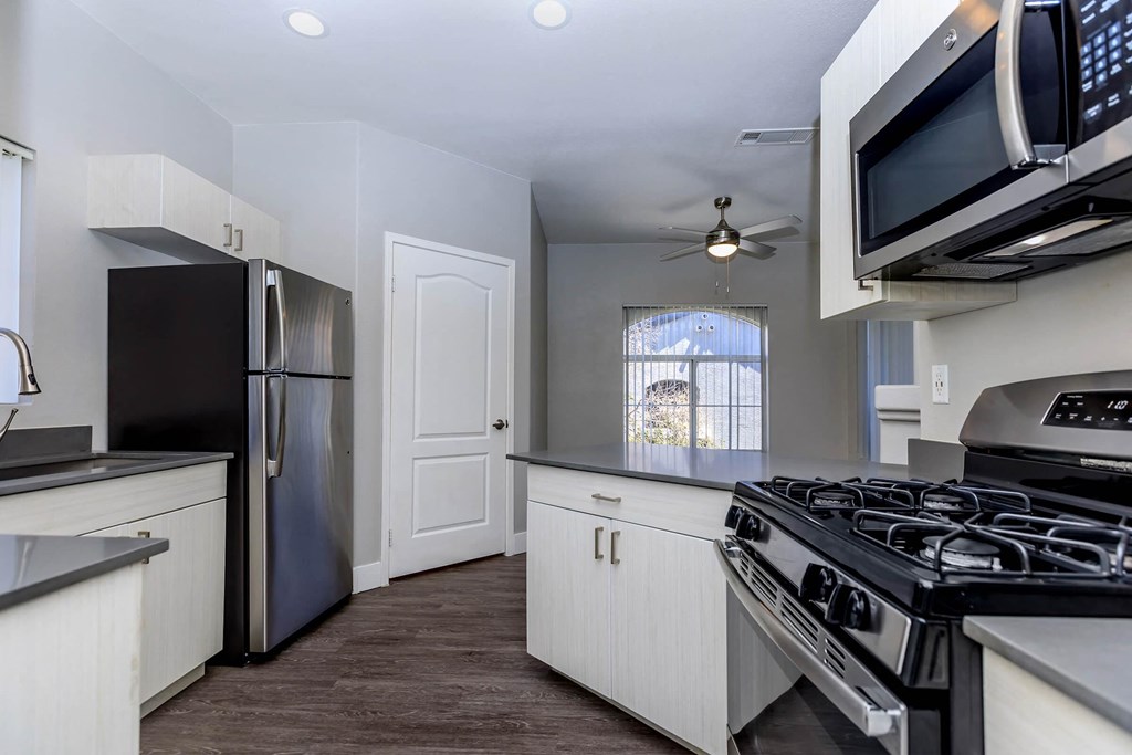 a kitchen with white cabinets and stainless steel appliances
