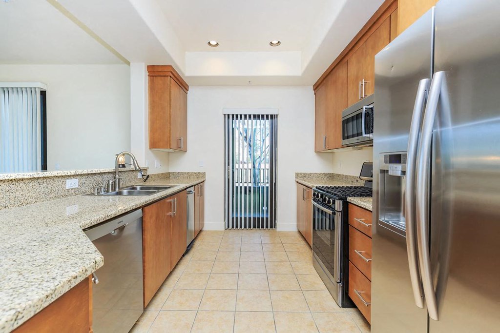 a large kitchen with stainless steel appliances and granite counter tops