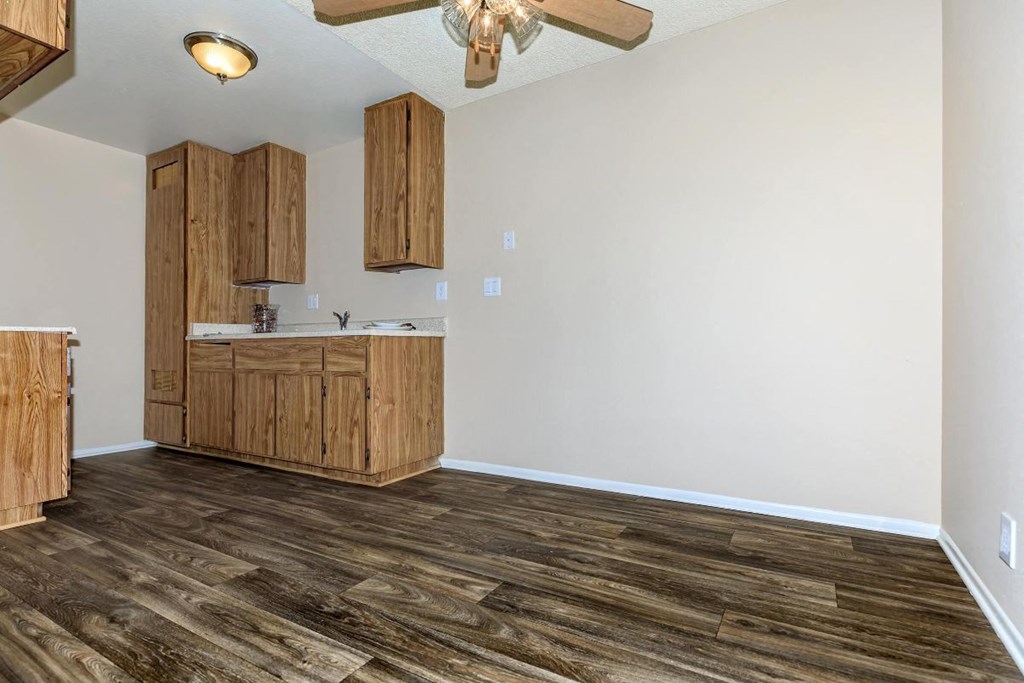 A kitchen with wooden floors and cabinets.