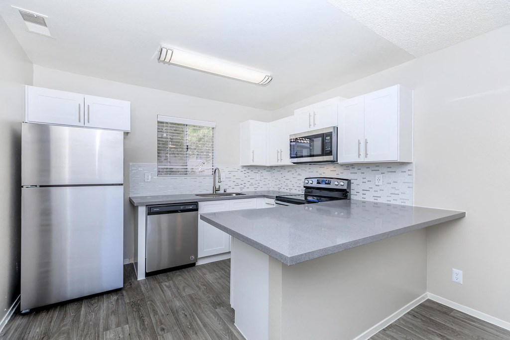 a kitchen with stainless steel appliances and white cabinets