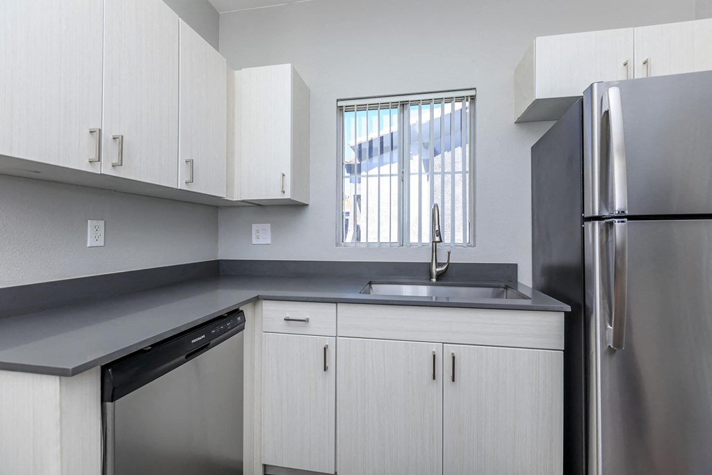 a kitchen with white cabinets and a stainless steel refrigerator
