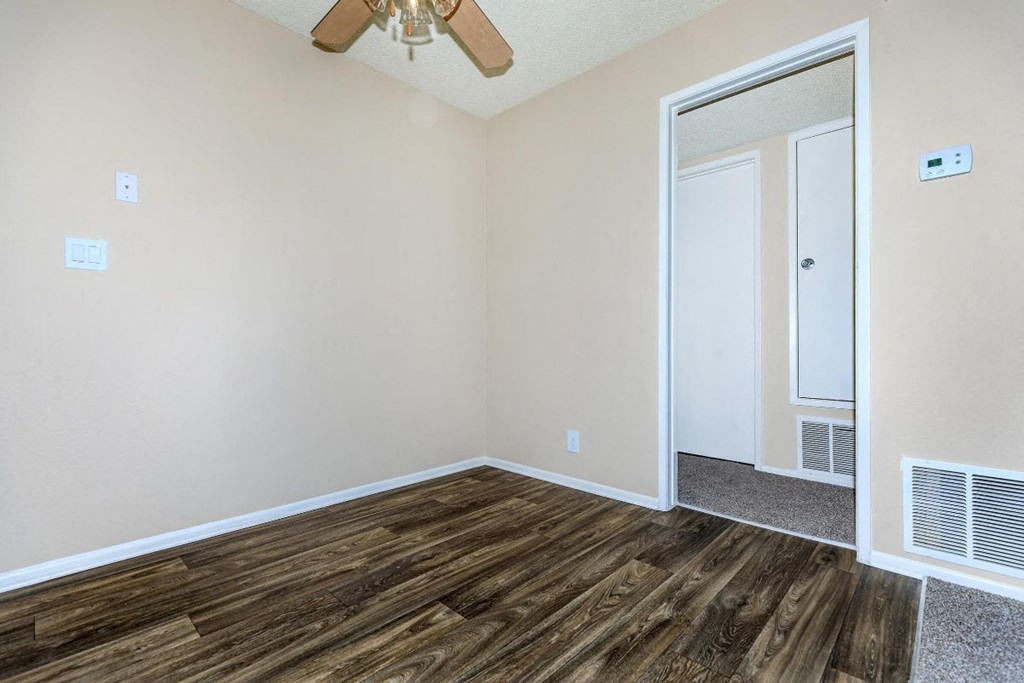 A room with a wooden floor and a ceiling fan.