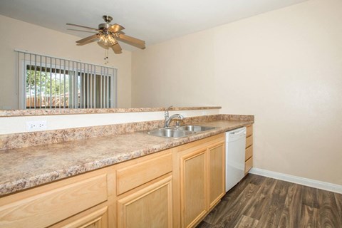 A kitchen with wooden cabinets and a granite countertop.
