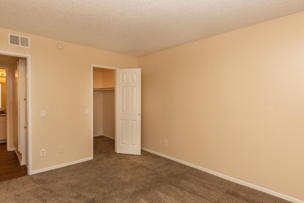 an empty living room with a door to a closet