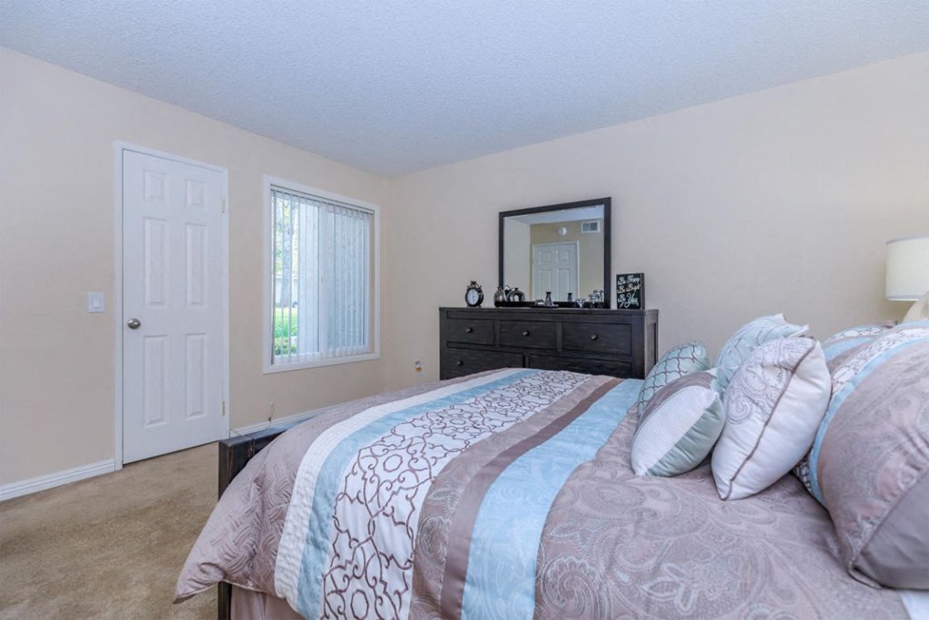 a bedroom with a bed and a dresser and a window