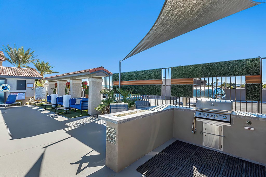 a patio with a grill and a table with chairs