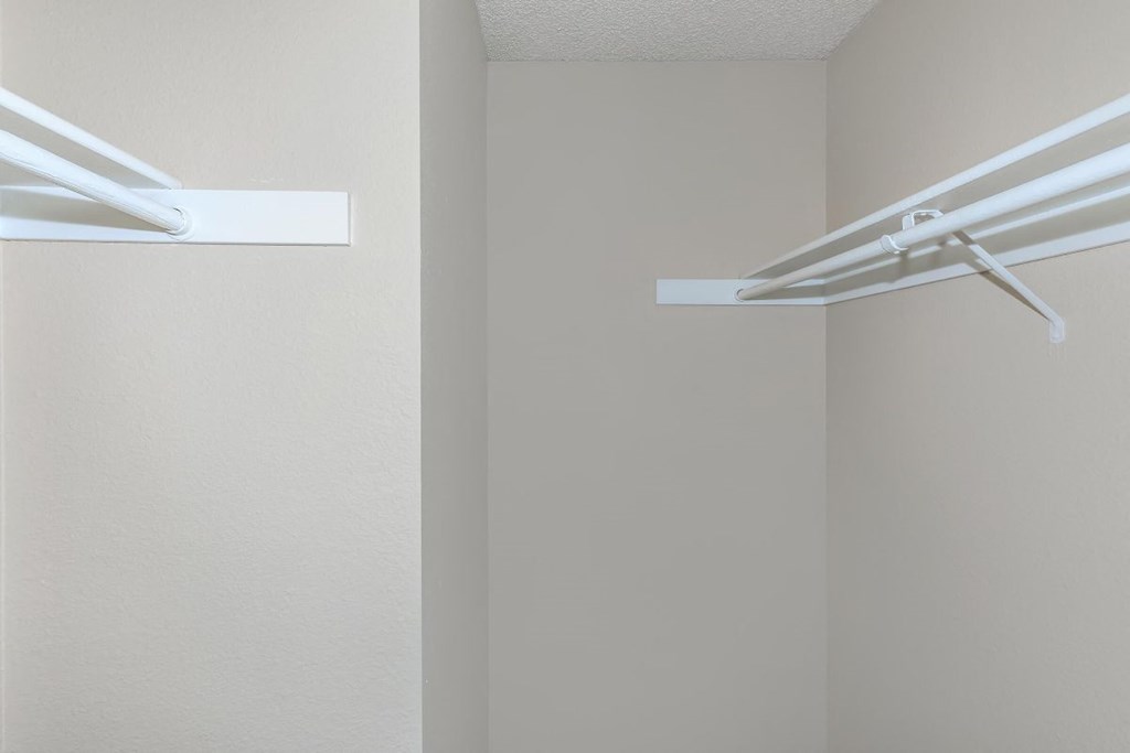 Two white shelves are mounted on a wall.