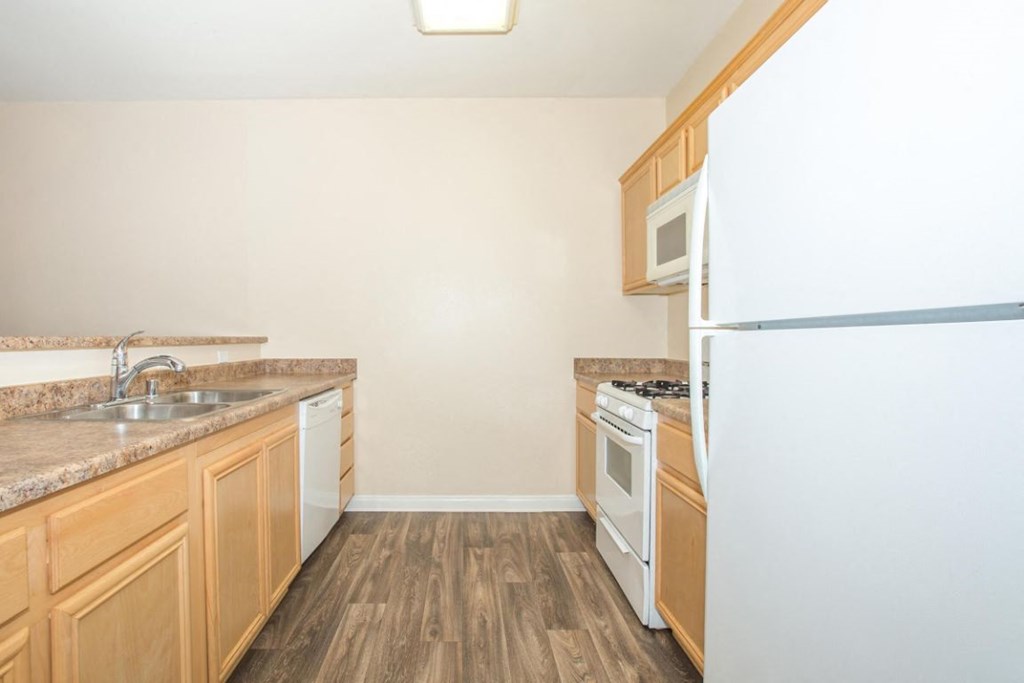 A kitchen with wooden cabinets and a white refrigerator.