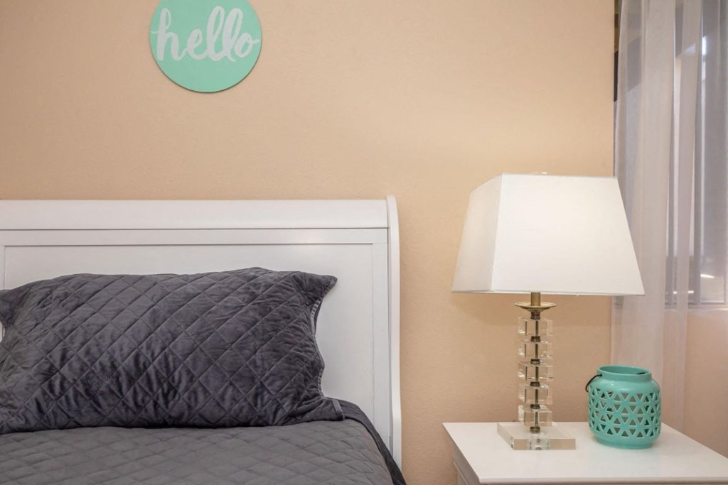 a bedroom with a bed and a table with a lamp