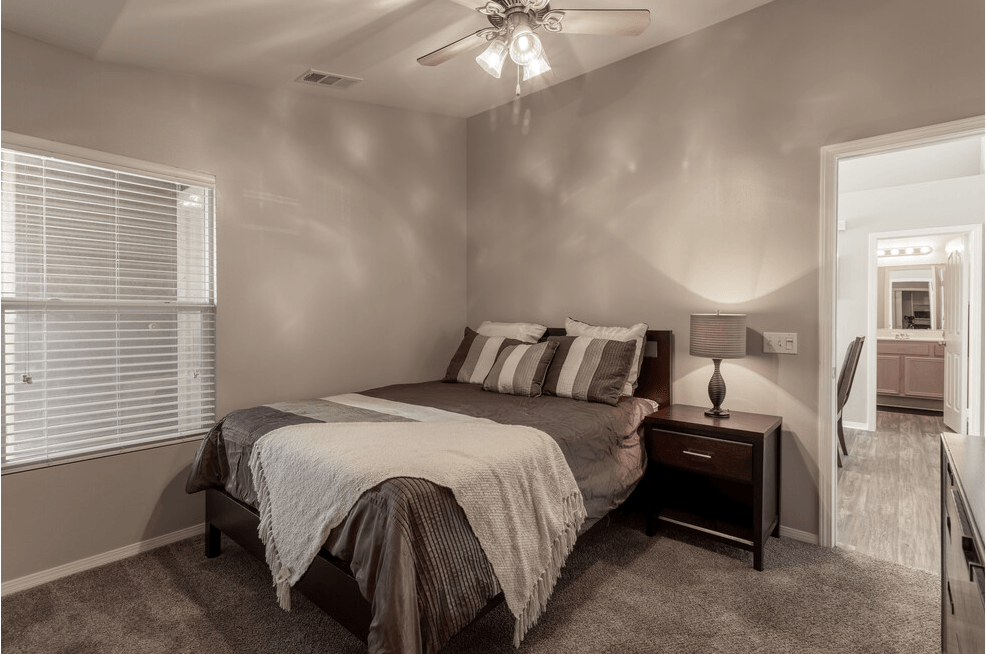 a bedroom with a bed and a ceiling fan