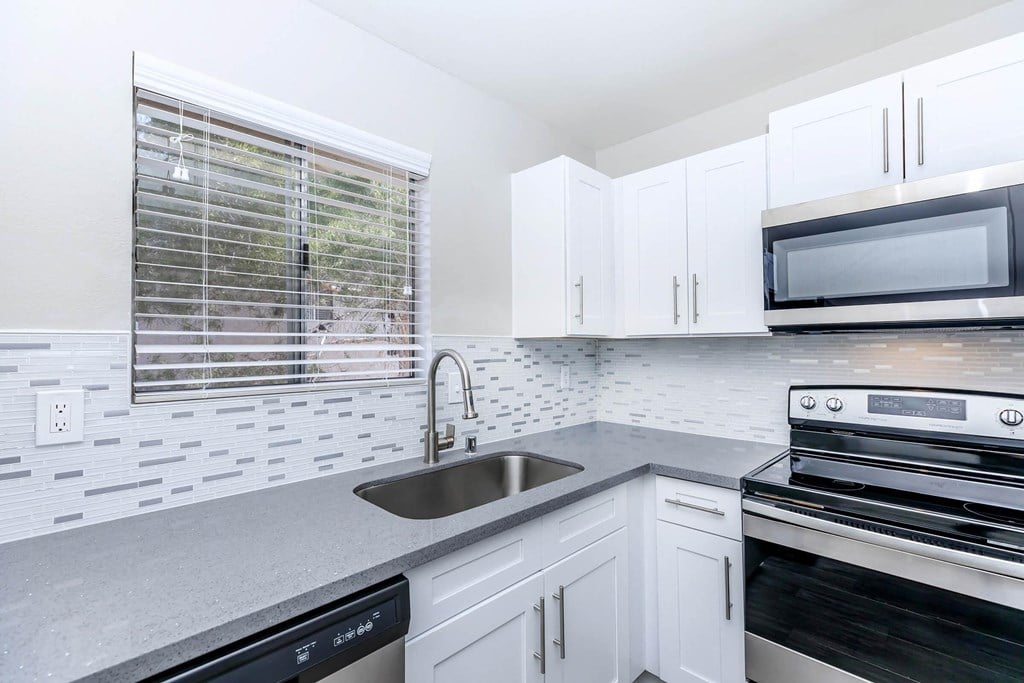 a kitchen with white cabinets and a sink