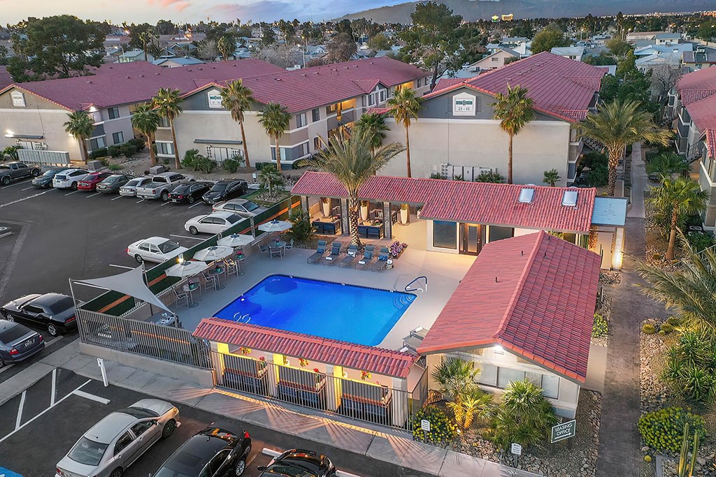 a building with a swimming pool in front of a parking lot