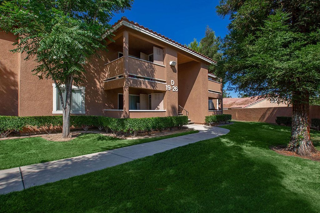 an apartment building with a sidewalk in front of it