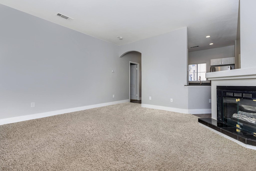 a living room with a fireplace and a carpeted floor