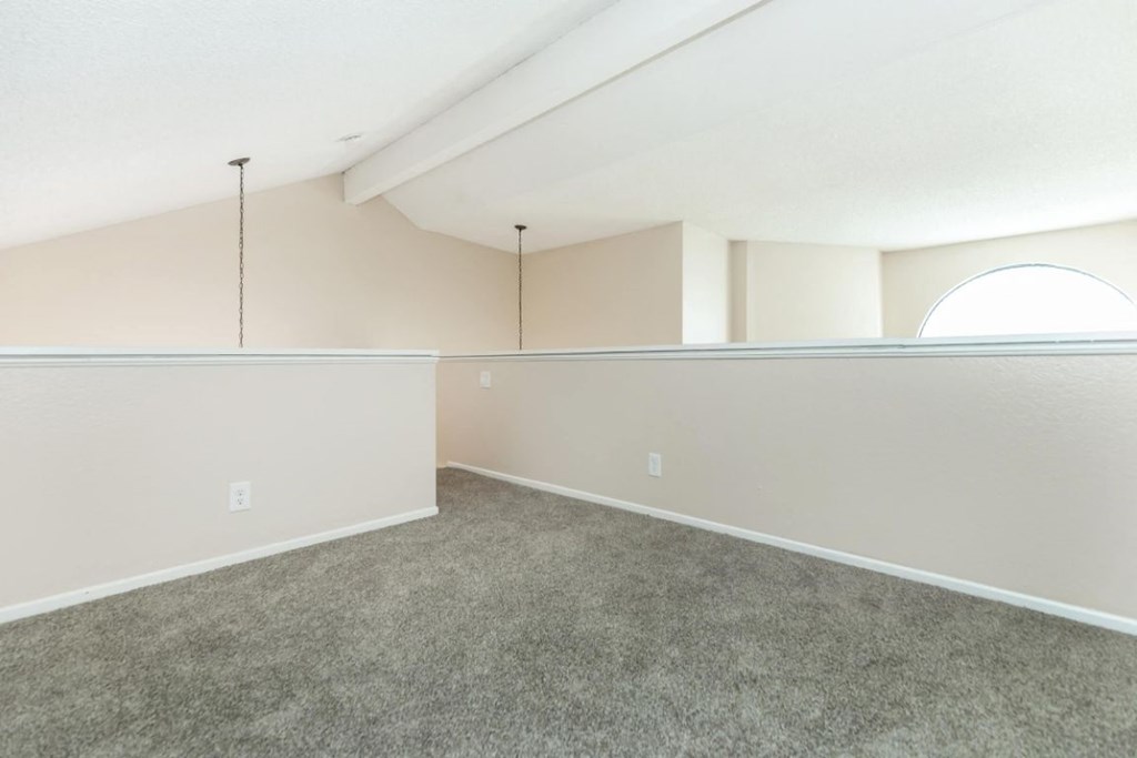 an empty living room with carpet and white walls